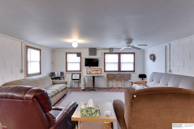 living room with concrete block wall and a ceiling fan