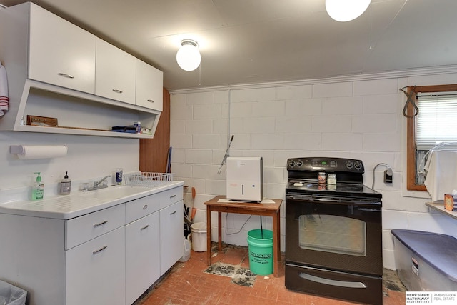 kitchen featuring electric range, light countertops, white cabinetry, open shelves, and a sink