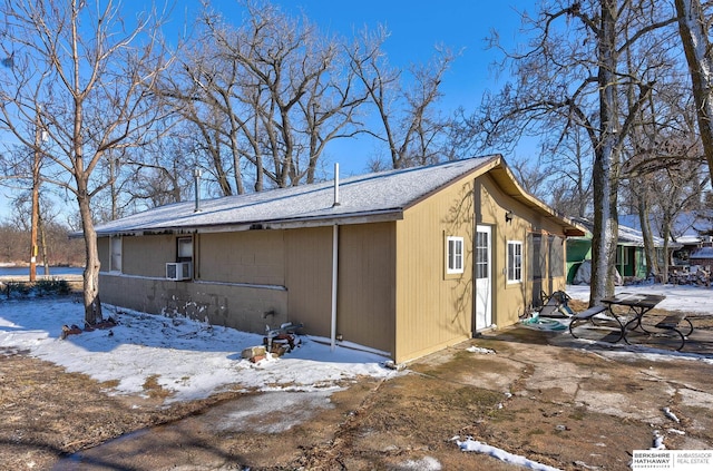 view of snowy exterior featuring cooling unit and a patio area