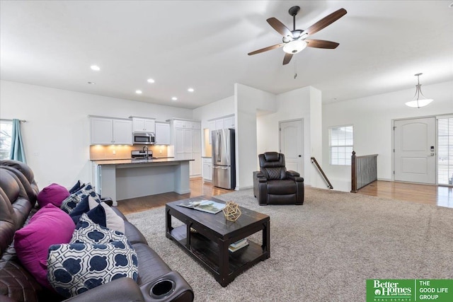 living area with light wood-type flooring, ceiling fan, light colored carpet, and recessed lighting