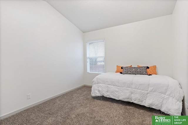 carpeted bedroom with lofted ceiling and baseboards