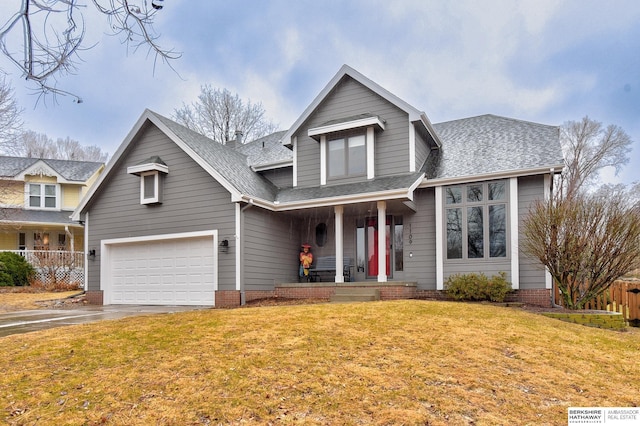 traditional-style home featuring driveway, a porch, a front yard, and a shingled roof