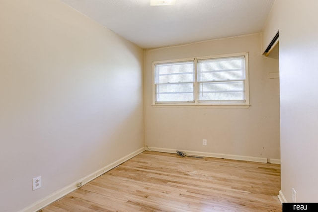 unfurnished room featuring baseboards and light wood-style floors