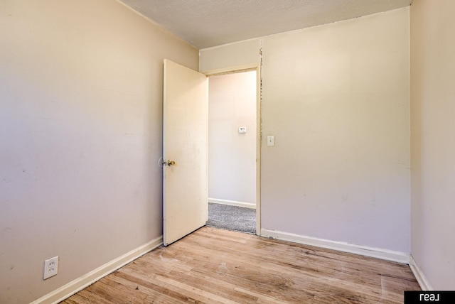 spare room with light wood-type flooring and baseboards