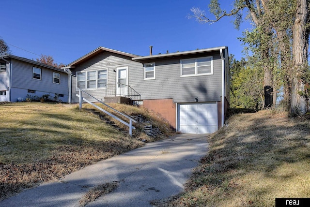 view of front of house featuring an attached garage, a front lawn, and concrete driveway