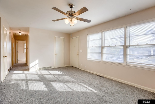 empty room featuring baseboards, visible vents, ceiling fan, and carpet flooring