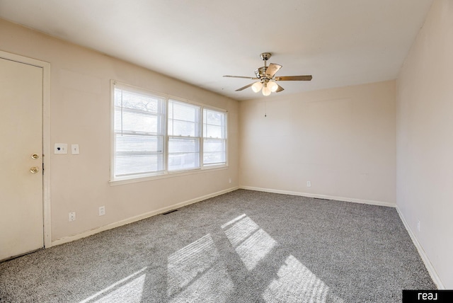 carpeted empty room with a ceiling fan, visible vents, and baseboards