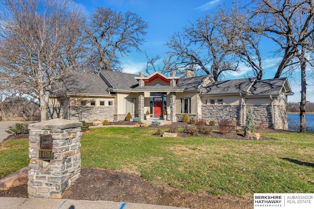 view of front of house featuring stone siding, a chimney, and a front yard