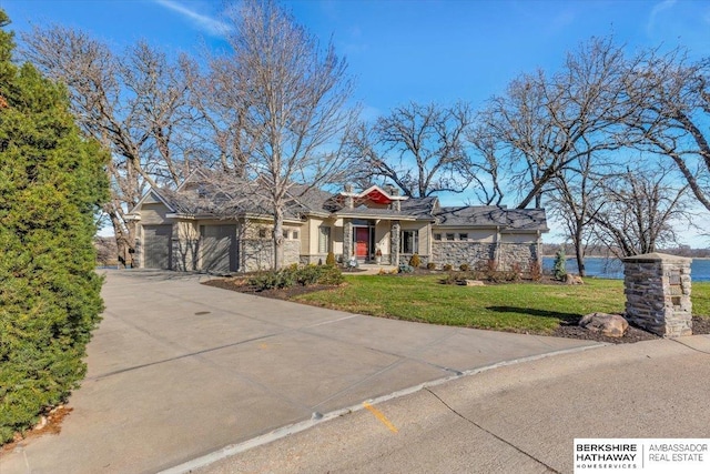 view of front facade featuring a garage, concrete driveway, and a front lawn