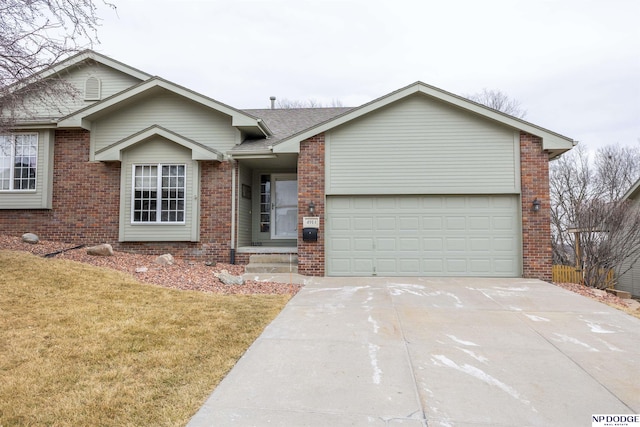 ranch-style house featuring a front yard, brick siding, driveway, and an attached garage