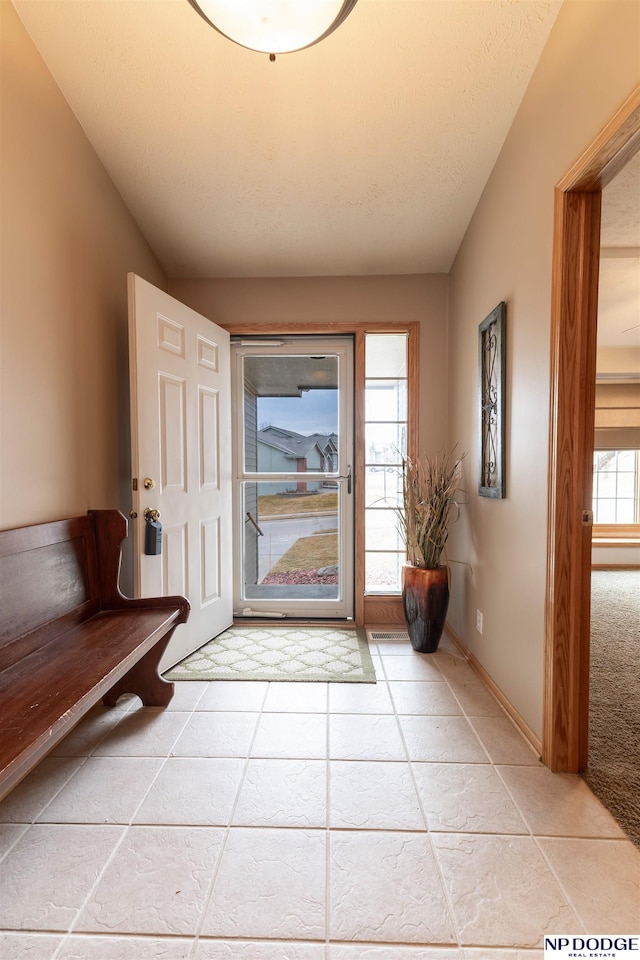 entryway featuring a textured ceiling and baseboards