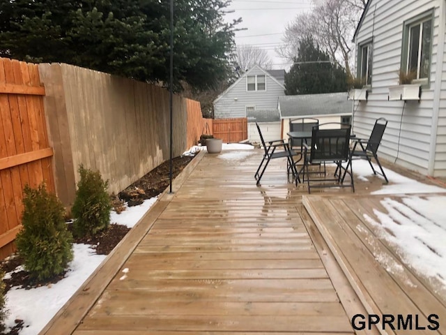 deck featuring outdoor dining area and a fenced backyard