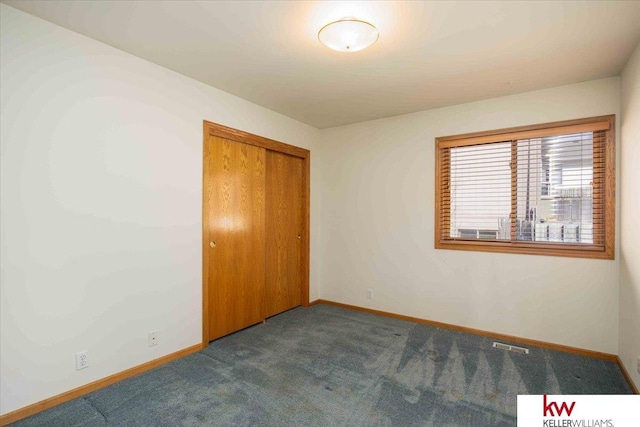 unfurnished bedroom featuring a closet, baseboards, carpet, and visible vents