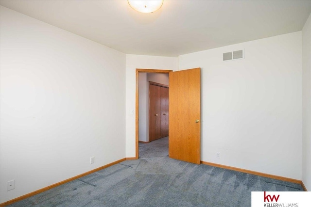 carpeted spare room with visible vents and baseboards