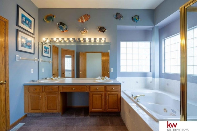 full bathroom with a sink, a tub with jets, and double vanity