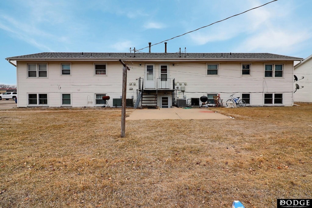 back of property with a patio area, a lawn, and cooling unit