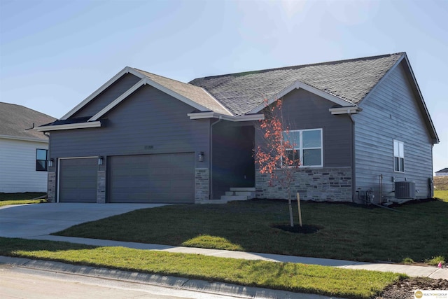 single story home with an attached garage, central AC, concrete driveway, stone siding, and a front yard