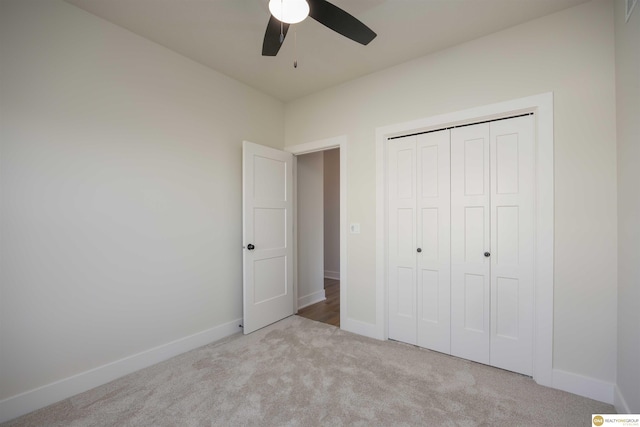 unfurnished bedroom featuring a ceiling fan, carpet, a closet, and baseboards