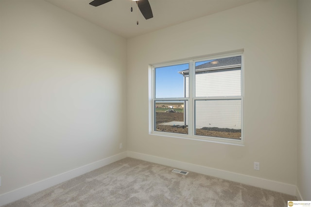 carpeted spare room with ceiling fan, visible vents, and baseboards