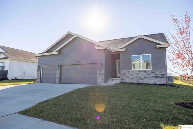 ranch-style home with stone siding, central AC, concrete driveway, and a front yard