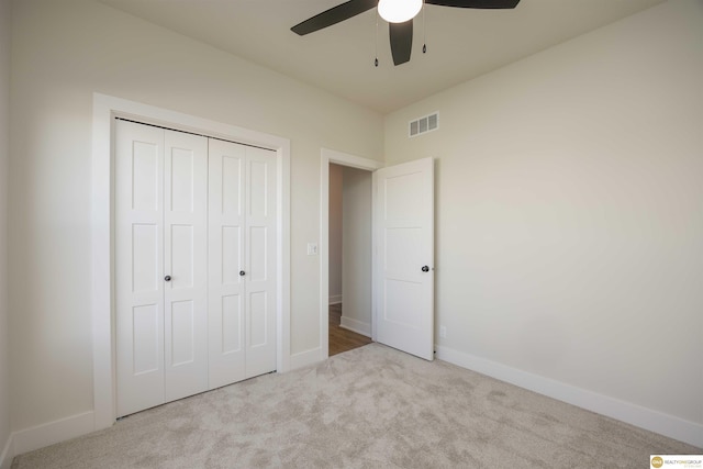 unfurnished bedroom with carpet, a closet, visible vents, and baseboards