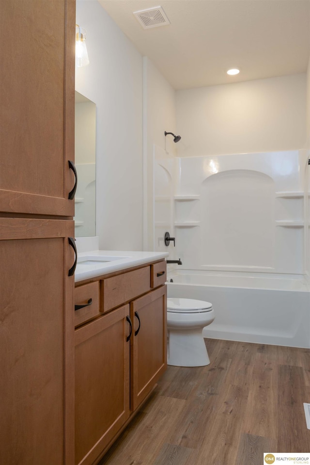 full bathroom featuring visible vents, toilet, wood finished floors,  shower combination, and vanity