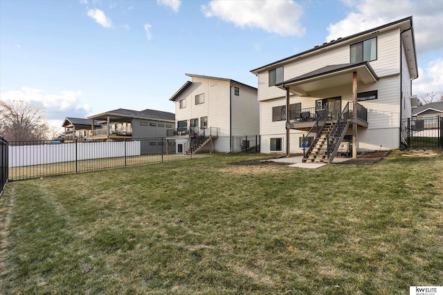 back of house with a deck, stairway, a fenced backyard, and a lawn