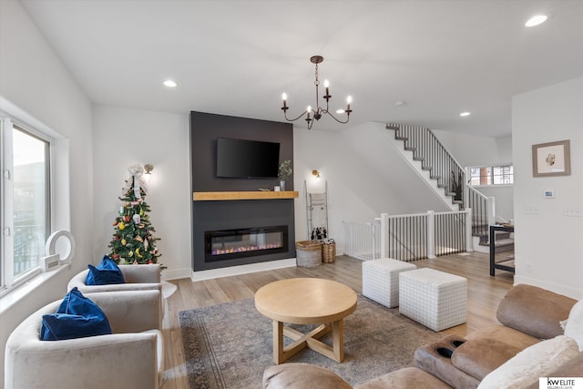 living room featuring recessed lighting, a large fireplace, wood finished floors, baseboards, and stairs