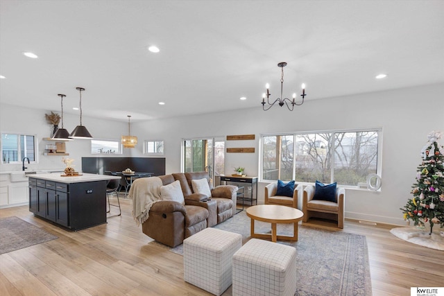 living area featuring a chandelier, light wood-type flooring, baseboards, and recessed lighting