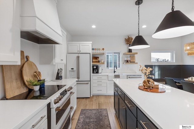 kitchen featuring high end appliances, custom range hood, white cabinetry, open shelves, and a sink