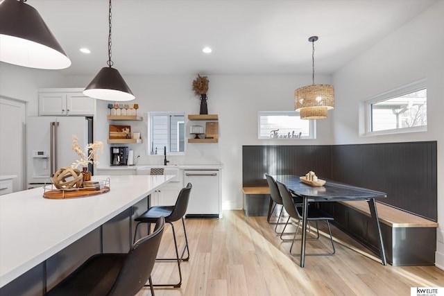 kitchen with open shelves, white appliances, light countertops, and a healthy amount of sunlight