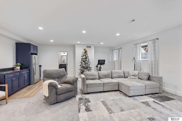 living area with light wood-style floors, baseboards, visible vents, and recessed lighting