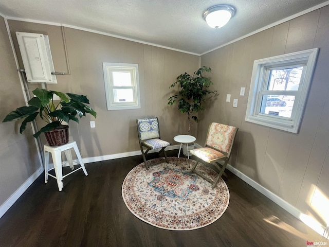 sitting room with crown molding, plenty of natural light, and wood finished floors