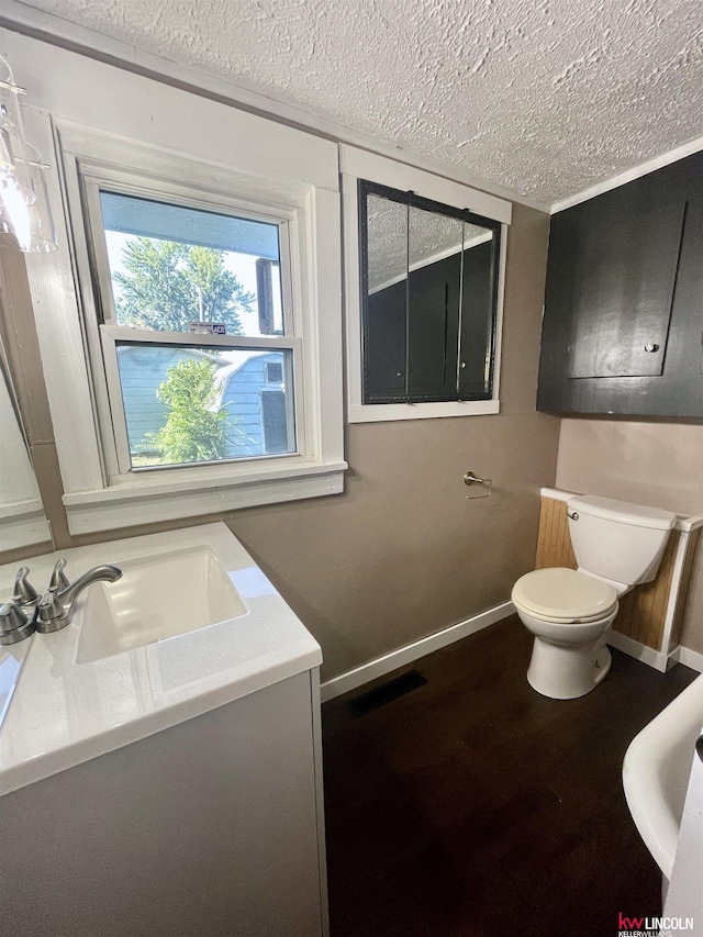 bathroom featuring toilet, baseboards, a textured ceiling, and wood finished floors