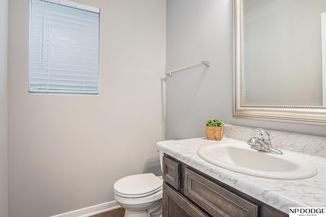 bathroom featuring baseboards, vanity, and toilet