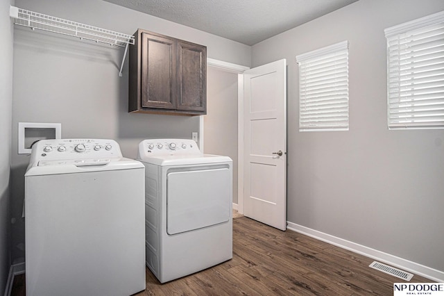 laundry room with cabinet space, baseboards, visible vents, dark wood-type flooring, and independent washer and dryer