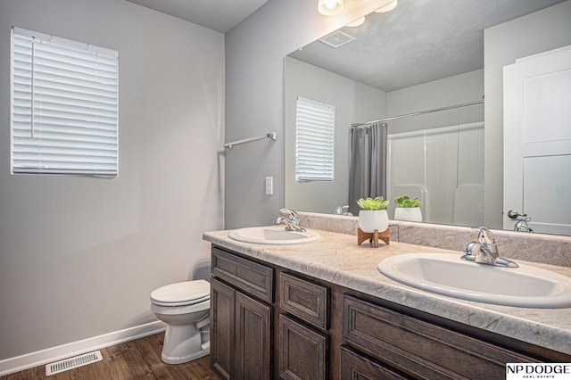 full bath featuring visible vents, a sink, toilet, and wood finished floors