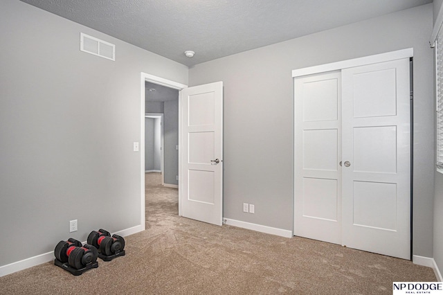 unfurnished bedroom with carpet flooring, visible vents, and baseboards