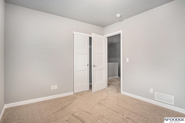 unfurnished bedroom featuring a closet, carpet, visible vents, and baseboards