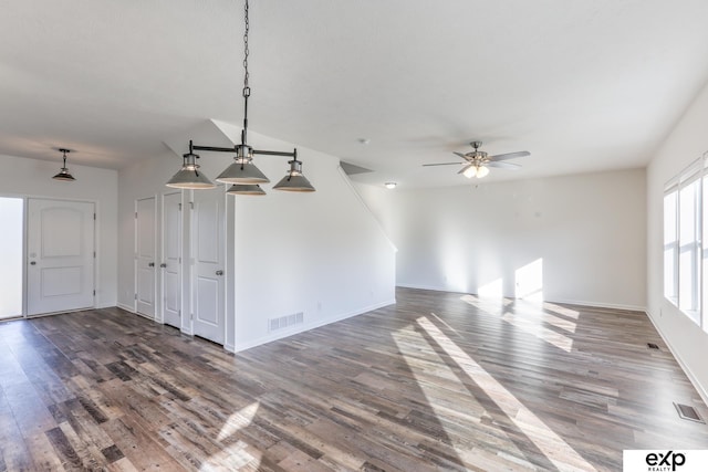 unfurnished living room with a ceiling fan, visible vents, and wood finished floors