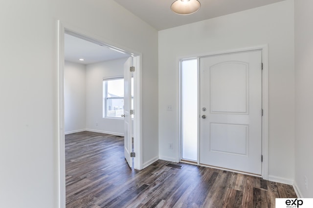 foyer featuring dark wood-type flooring and baseboards