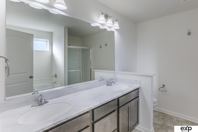 full bath featuring double vanity, a stall shower, a sink, and toilet