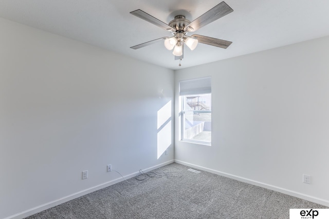 carpeted spare room with a ceiling fan, visible vents, and baseboards