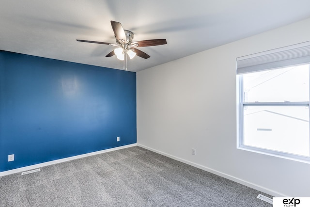 empty room featuring a ceiling fan, carpet flooring, visible vents, and baseboards