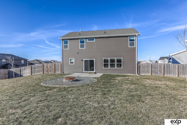 back of house featuring a fire pit, a lawn, and a fenced backyard