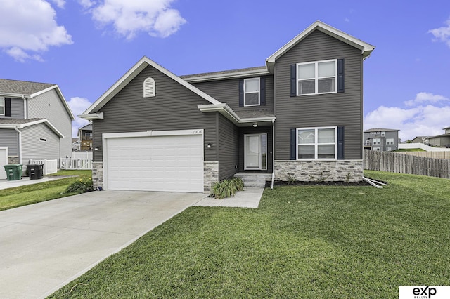 traditional-style house with stone siding, fence, concrete driveway, and a front yard