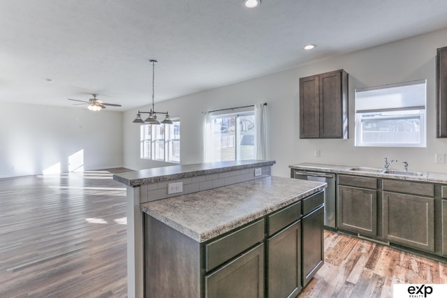 kitchen featuring recessed lighting, a sink, stainless steel dishwasher, a center island, and light wood finished floors