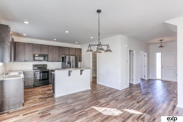 kitchen featuring dark wood-style floors, black appliances, a sink, and light countertops