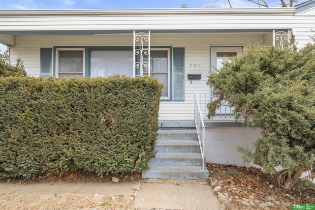 view of exterior entry featuring covered porch