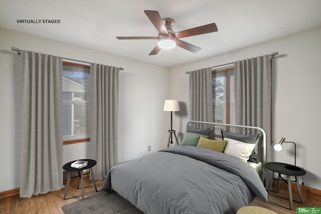 bedroom with baseboards, a ceiling fan, and wood finished floors